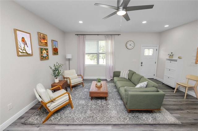 living area with a ceiling fan, wood finished floors, and a healthy amount of sunlight