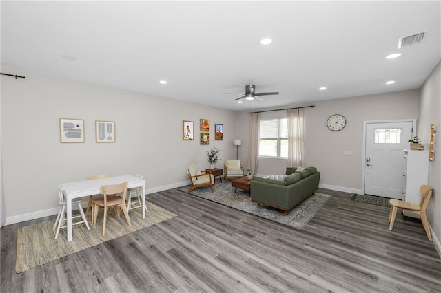 living area with visible vents, baseboards, a ceiling fan, and wood finished floors
