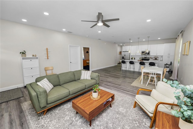 living area featuring recessed lighting, baseboards, a ceiling fan, and wood finished floors
