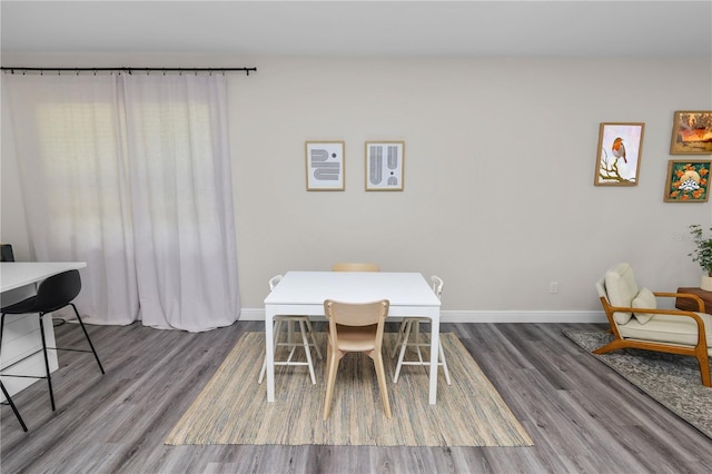 dining space featuring baseboards and dark wood-style floors