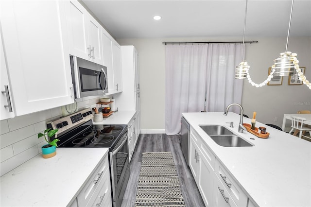 kitchen with tasteful backsplash, dark wood-style flooring, white cabinetry, stainless steel appliances, and a sink