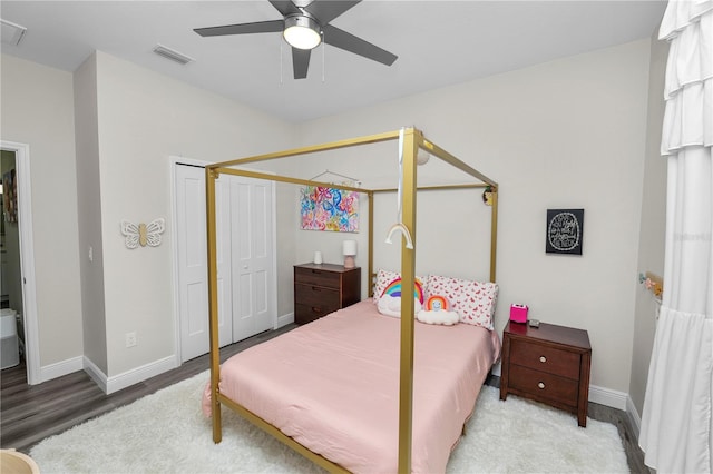 bedroom with ceiling fan, visible vents, baseboards, and wood finished floors