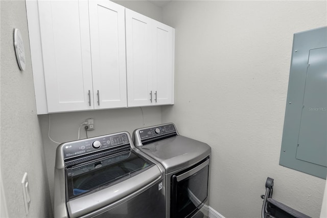 washroom with electric panel, washing machine and clothes dryer, and cabinet space