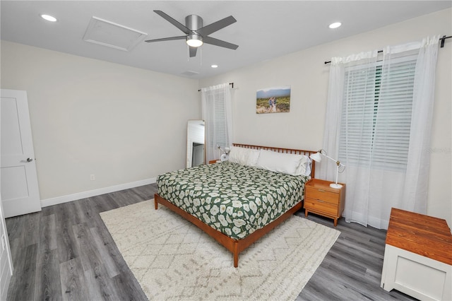 bedroom with wood finished floors, attic access, baseboards, and recessed lighting