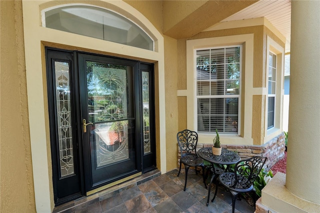 doorway to property with stucco siding and a porch