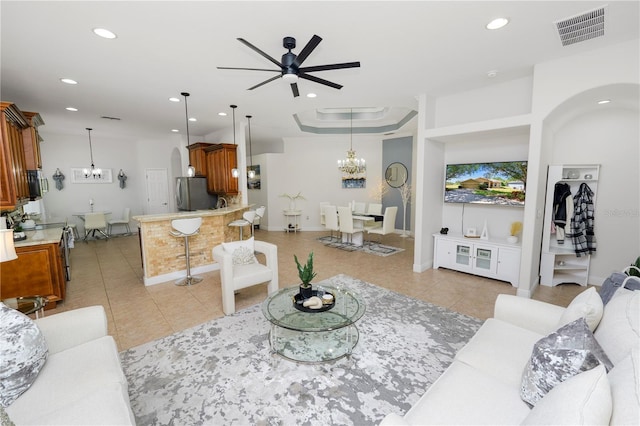 living area featuring a ceiling fan, light tile patterned flooring, arched walkways, recessed lighting, and a chandelier