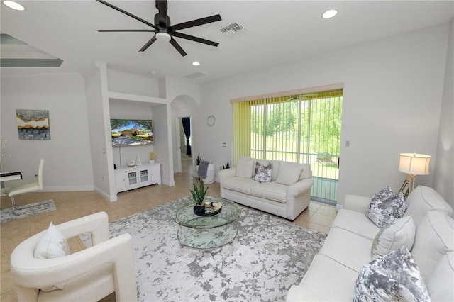 tiled living area with a ceiling fan, recessed lighting, arched walkways, and baseboards