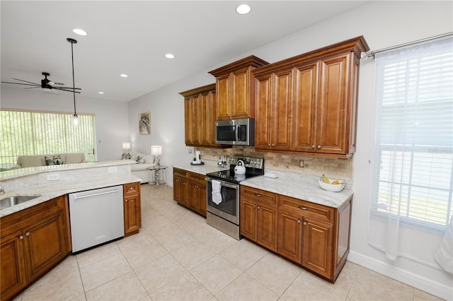 kitchen featuring appliances with stainless steel finishes, ceiling fan, brown cabinetry, and recessed lighting