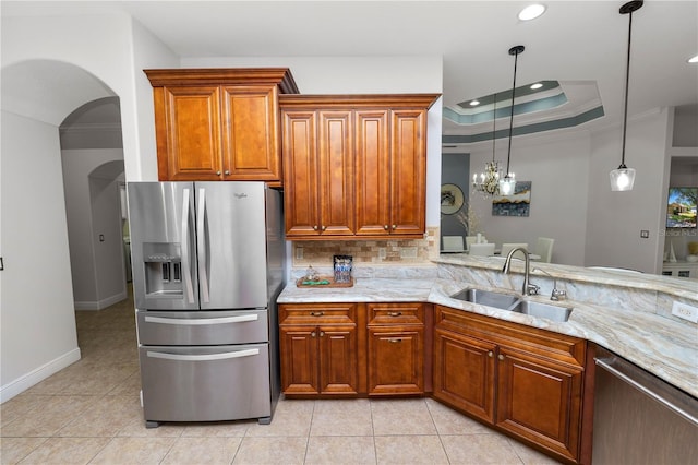 kitchen featuring stainless steel appliances, a sink, light tile patterned floors, light stone counters, and crown molding