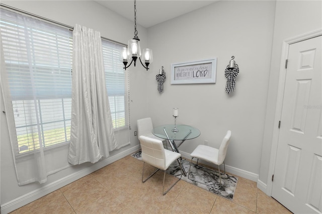 dining space featuring a chandelier, baseboards, and tile patterned flooring