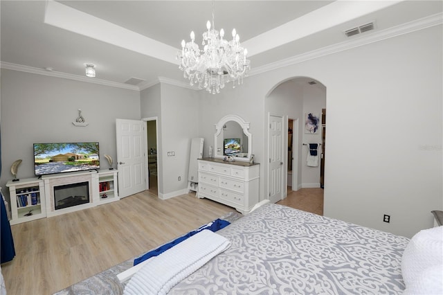 bedroom with arched walkways, ornamental molding, a chandelier, a raised ceiling, and baseboards