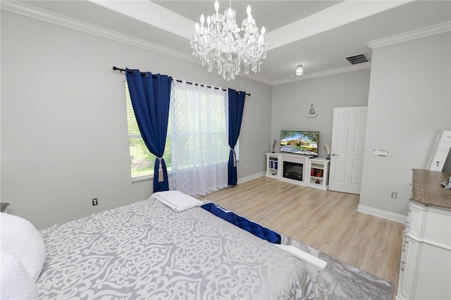 bedroom featuring light wood-type flooring, a chandelier, ornamental molding, and baseboards