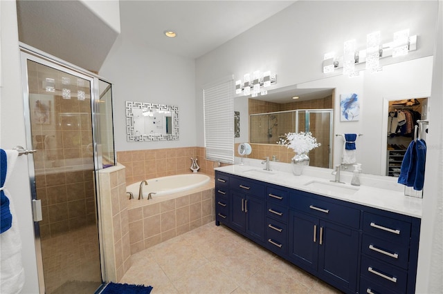 full bath featuring tile patterned floors, a stall shower, a garden tub, double vanity, and a spacious closet
