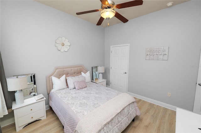 bedroom featuring light wood finished floors, baseboards, and ceiling fan