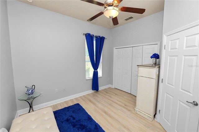 unfurnished bedroom with light wood finished floors, a closet, ceiling fan, and baseboards