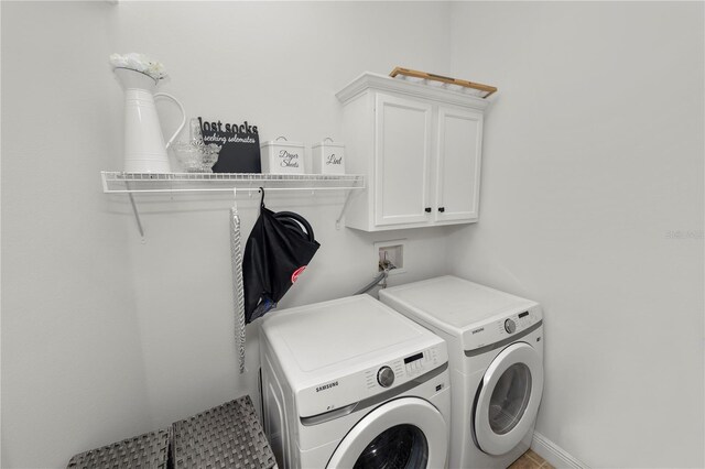 washroom with washing machine and clothes dryer and cabinet space