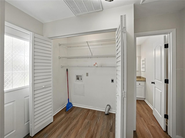 laundry room with laundry area, visible vents, dark wood finished floors, electric dryer hookup, and washer hookup