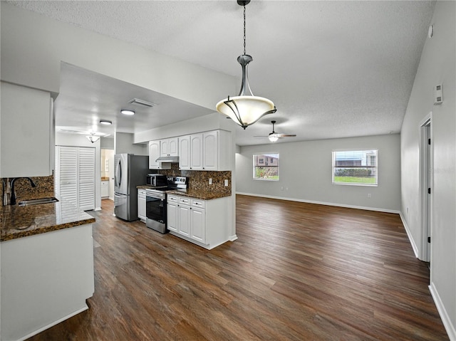 kitchen with a ceiling fan, a sink, white cabinetry, backsplash, and appliances with stainless steel finishes