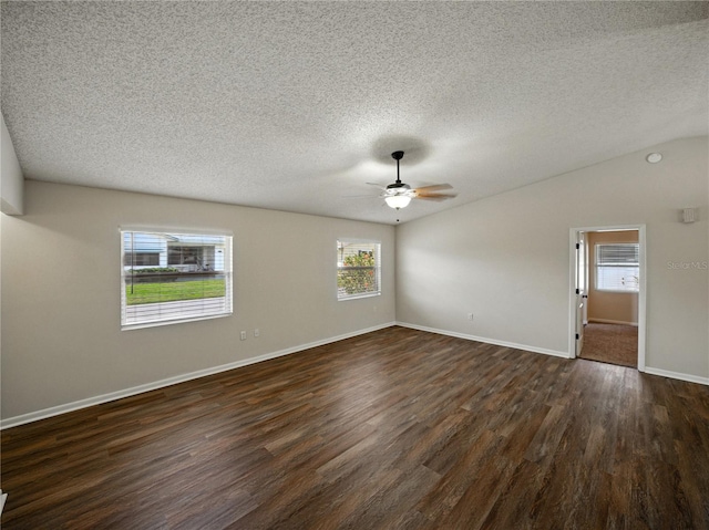 unfurnished room with a wealth of natural light, dark wood-style flooring, a ceiling fan, and a textured ceiling