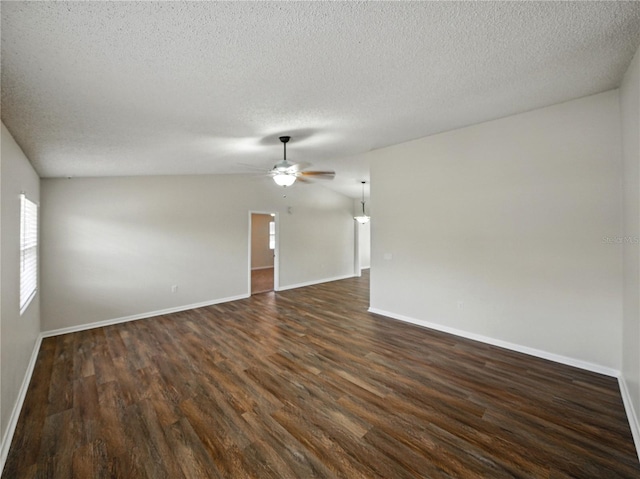spare room featuring a wealth of natural light, ceiling fan, a textured ceiling, and dark wood-type flooring