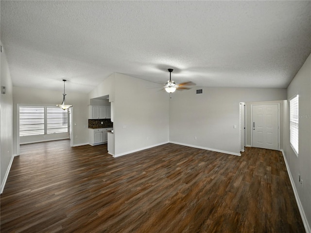 unfurnished living room featuring baseboards, lofted ceiling, ceiling fan, and dark wood-style floors