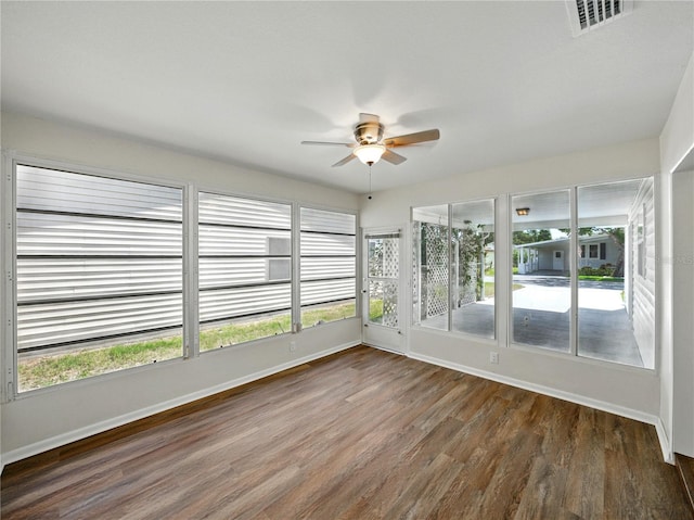 unfurnished sunroom with visible vents and a ceiling fan