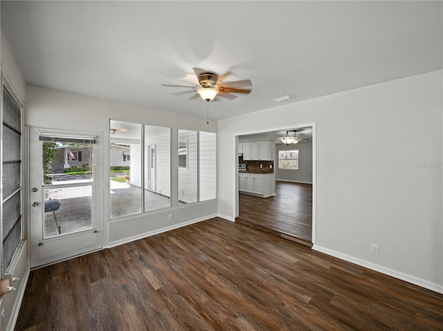 unfurnished room with dark wood finished floors and a ceiling fan