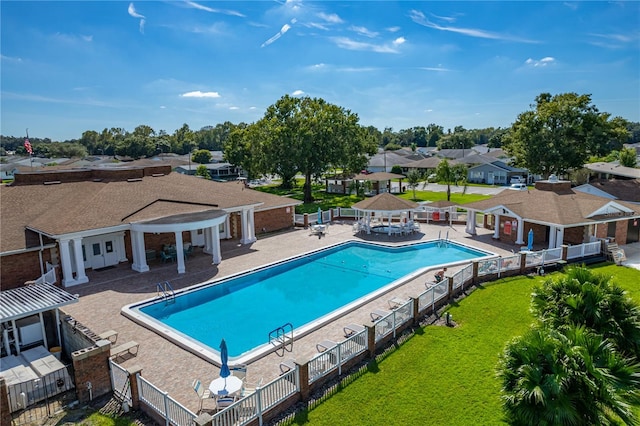 pool featuring fence, a patio area, a residential view, a pergola, and a lawn