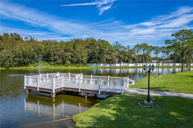 dock area with a yard and a water view