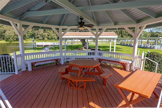 wooden deck featuring a yard, a water view, a gazebo, and ceiling fan