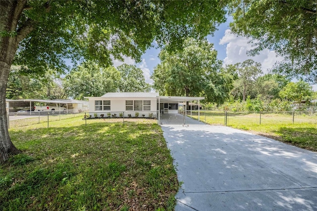 ranch-style home featuring fence, a front lawn, a gate, driveway, and an attached carport