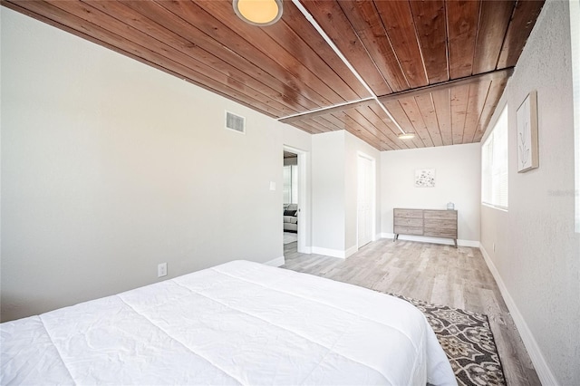 bedroom with wood ceiling, baseboards, visible vents, and light wood-style floors