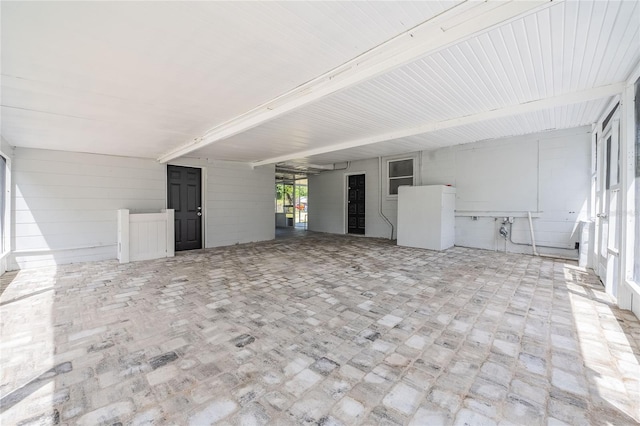 unfurnished living room with brick floor