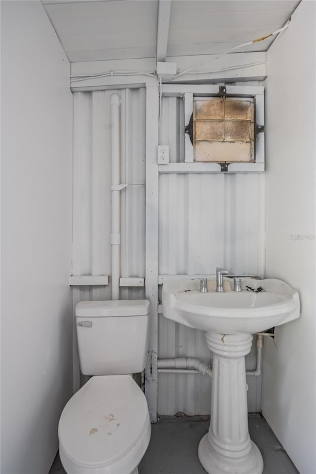 bathroom featuring concrete floors and toilet
