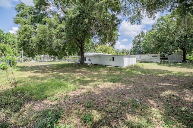view of yard featuring an outdoor structure and fence