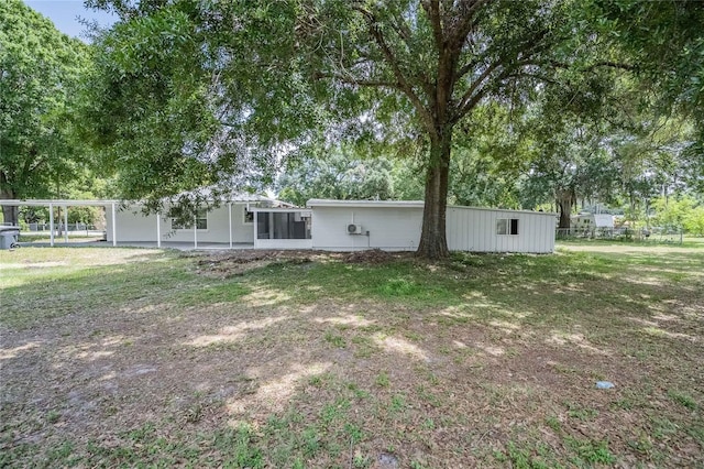 back of property with fence, a carport, and a sunroom