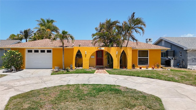 4921 Marlin Dr, New Port Richey, FL 34652 - single story home featuring curved driveway, stucco siding, roof with shingles, a front lawn, and an attached garage