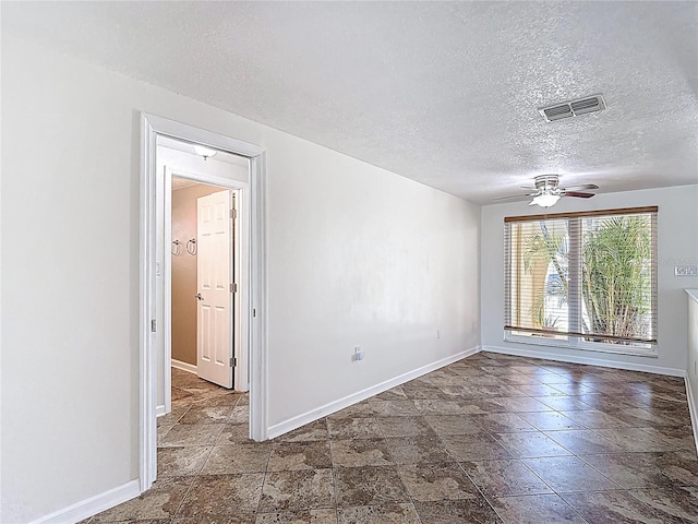 4921 Marlin Dr, New Port Richey, FL 34652 - spare room with baseboards, a textured ceiling, visible vents, ceiling fan, and stone finish flooring