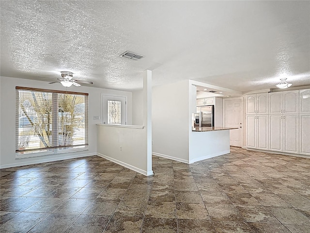 4921 Marlin Dr, New Port Richey, FL 34652 - spare room featuring a textured ceiling, ceiling fan, baseboards, and visible vents