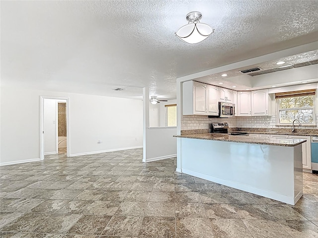 4921 Marlin Dr, New Port Richey, FL 34652 - kitchen with baseboards, a textured ceiling, and appliances with stainless steel finishes