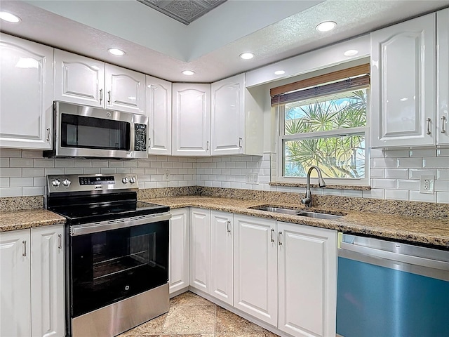 4921 Marlin Dr, New Port Richey, FL 34652 - kitchen with white cabinets, recessed lighting, a sink, and appliances with stainless steel finishes
