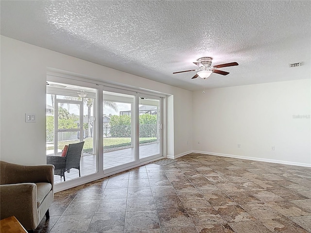 4921 Marlin Dr, New Port Richey, FL 34652 - spare room with baseboards, a textured ceiling, visible vents, ceiling fan, and stone finish flooring