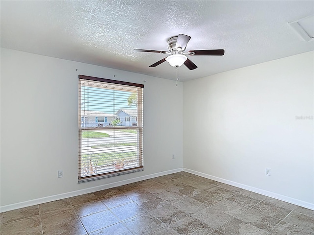 4921 Marlin Dr, New Port Richey, FL 34652 - empty room featuring a textured ceiling, baseboards, a ceiling fan, and stone finish flooring