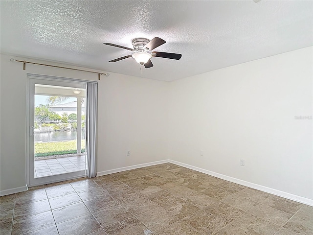 4921 Marlin Dr, New Port Richey, FL 34652 - empty room featuring a textured ceiling, baseboards, a ceiling fan, and a water view