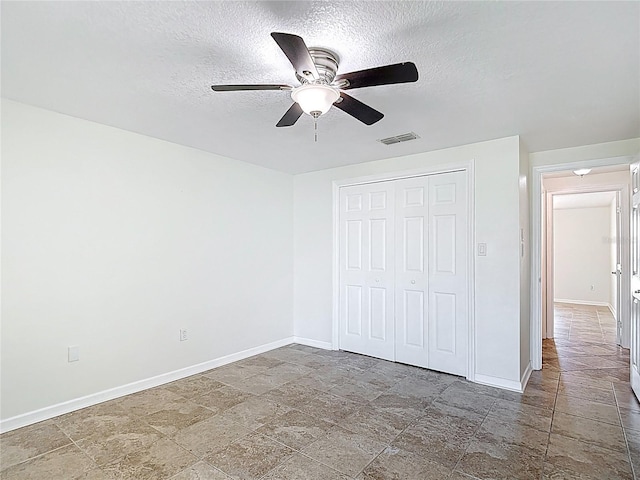 4921 Marlin Dr, New Port Richey, FL 34652 - unfurnished bedroom with a textured ceiling, a closet, visible vents, stone finish flooring, and baseboards