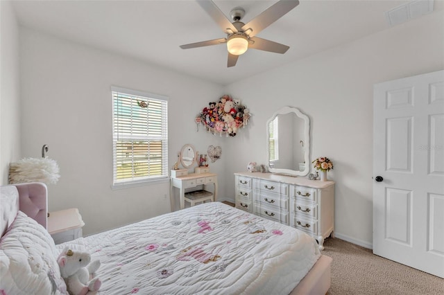 bedroom with baseboards, a ceiling fan, visible vents, and light colored carpet