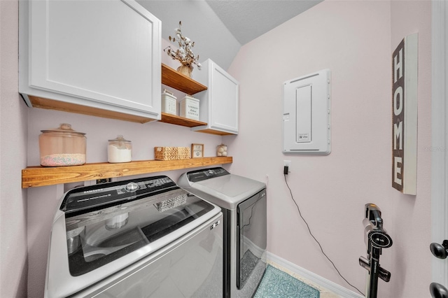 clothes washing area with baseboards, cabinet space, and washer and clothes dryer