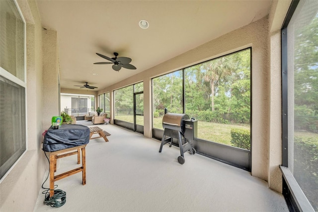 sunroom / solarium featuring a ceiling fan and a healthy amount of sunlight