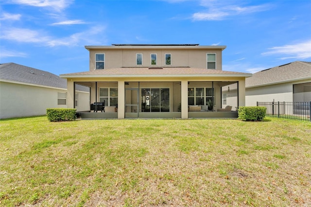 back of house with stucco siding, a yard, a sunroom, and fence
