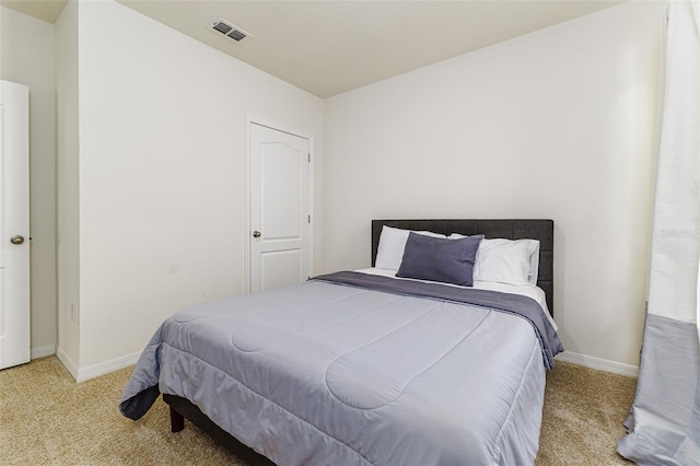 carpeted bedroom featuring baseboards and visible vents